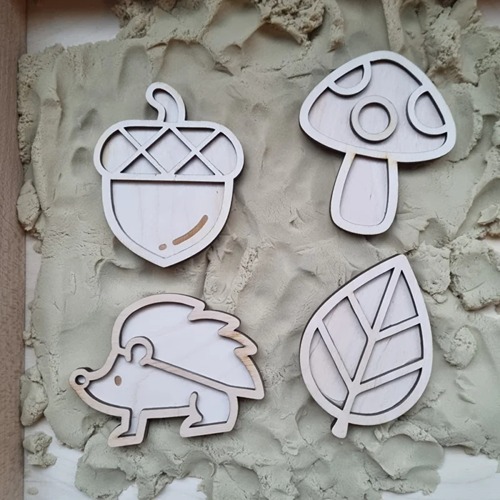 Eikel, egel, blad, paddestoel stempel zand houten mini vulvormen liggend op zand, te gebruiken met magisch zand en o.a. speelrijst voor sensorisch spel in thema herfst