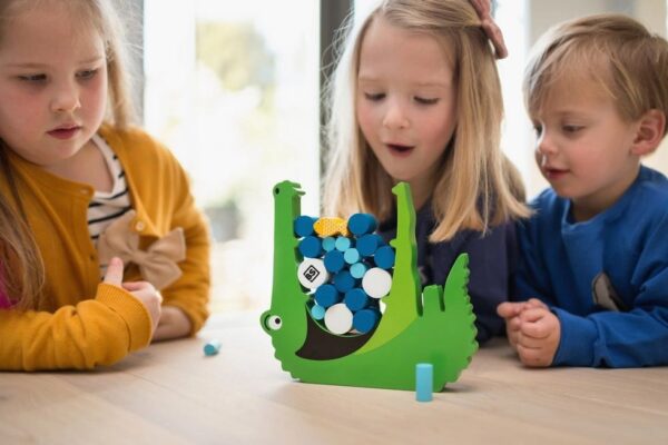 Kind speelt balansspel van BS Toys met hongerige krokodil
