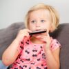 meisje-educatief-muziekspeelgoed-mondharmonica Kind speelt met New Classic Toys mondharmonica muziek speelgoed