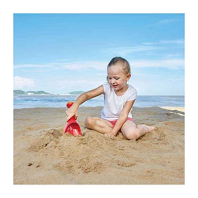 Kind speelt buiten met Hape regenschep zand en water schep