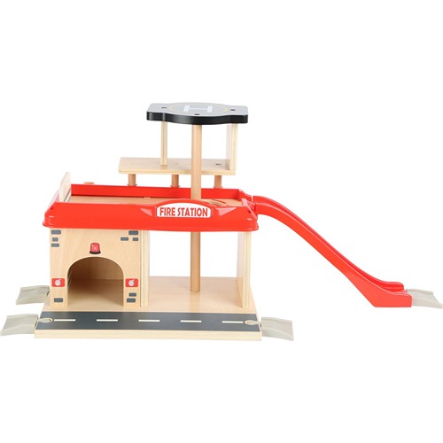 Close-up van de Small Foot brandweerkazerne met karakteristieke brandweerpaal/glijbaan en garages voor voertuigen – duurzaam houten speelgoed voor kinderen.